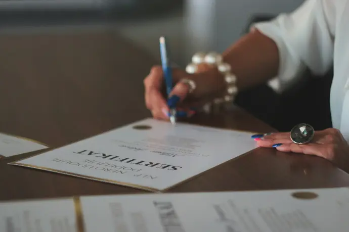 a woman writing on a piece of paper